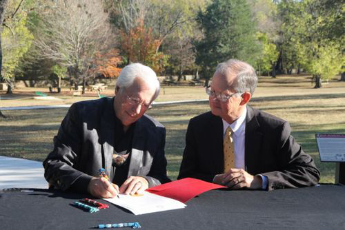 Cherokee Nation Principal Chief Bill John Baker and Dr. Bob Blackburn, executive director of the Oklahoma Historical Society, sign the official certificate of transfer for Sequoyah’s Cabin near Sallisaw, Oklahoma, on Nov. 9, 2016