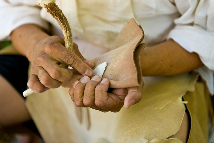 Hands crafting an arrowhead